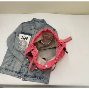 Binnendetail van een roze nylon trekkoordtas met binnenzakken en voering, close-up