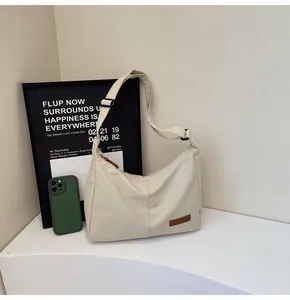 Lifestyle detail of the cream minimalist messenger bag on a shelf with modern decor