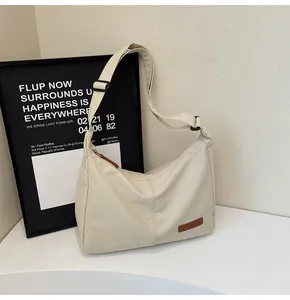 Detail view of the cream white large capacity nylon messenger bag for daily casual use.