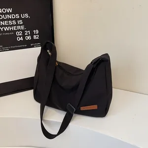 Minimalist black nylon crossbody messenger bag with large capacity for daily commuting.