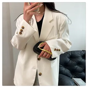 Elegant black evening clutch bag with a chunky gold curved metal handle detail.
