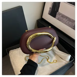 Sophisticated burgundy evening clutch bag featuring a striking gold C-shaped metal handle detail