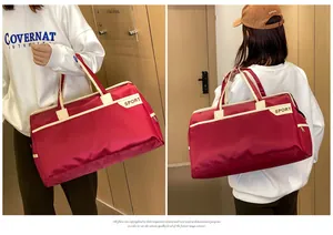 Detailansicht einer großen roten wasserdichten Reisetasche mit Tragebeispiel der Frau