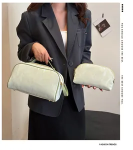 A model showcases a mint green textured makeup bag set featuring a handle and zipper.