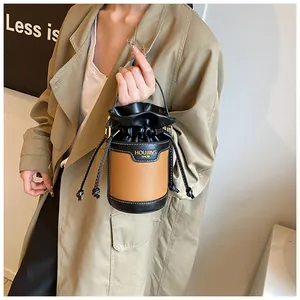 Stylish brown and black patchwork drawstring bucket bag shown in a fashion detail shot.