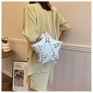 Stylish silver star-shaped crossbody bag worn by a model in a modern interior setting