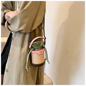 Close-up of stylish color-blocked drawstring bucket bag on model's shoulder