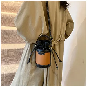 Close-up view of the two-tone bucket bag featuring contrasting stitching and drawstring