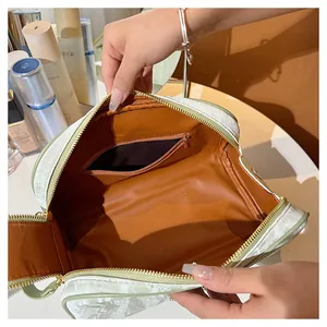 Interior detail of large capacity makeup bag with orange lining and zipper pocket
