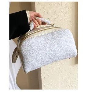 Close-up view of a stylish white sherpa furry cosmetic bag showing plush handle and zipper