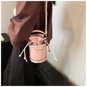 Close-up detail of a pink leather bucket bag with a stylish drawstring closure design