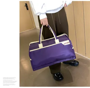 Detailansicht einer großen wasserdichten lila Reisetasche mit weißem Sport-Logo-Aufdruck.