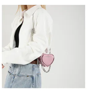 Detailed view of pink heart-shaped mini bag with beaded chain strap on model