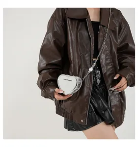 Silver heart-shaped mini crossbody bag with chain and bead detail on model