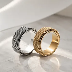 Close-up view of gold and silver mesh stainless steel spinner rings on stone surface