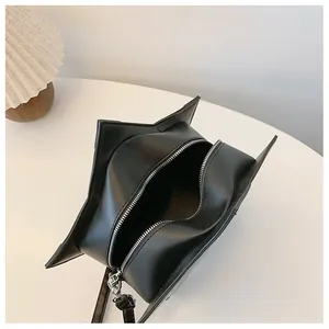 Detailed interior view of a black star-shaped crossbody bag with silver zipper closure.
