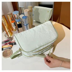 Detail view of a large capacity light green textured vanity bag on a makeup table setup