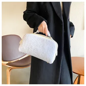 Model showcasing a large capacity fluffy white plush cosmetic bag against a black coat