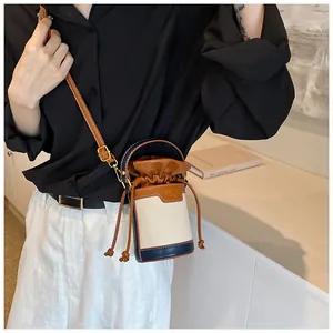 Detailed view of the women's patchwork cylindrical bucket bag with a drawstring closure