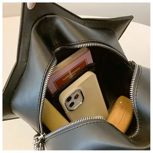 Detailed interior view of a black star-shaped crossbody bag showing storage capacity
