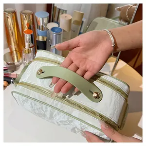 Detail showing the handle and crinkled texture of a large portable cosmetic bag.
