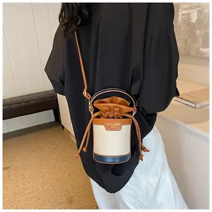 Stylish patchwork cylinder bucket bag with drawstring closure and crossbody strap