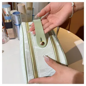 Close-up of a large capacity makeup bag featuring textured fabric and dual gold zippers