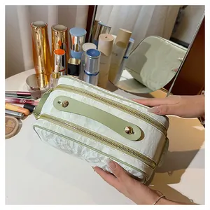 Close-up of a large capacity textured cosmetic bag with elegant dual gold zippers