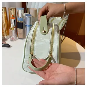 Detail view of the handle and dual gold zippers on a mint green cosmetic bag.