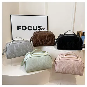 Crinkled texture cosmetic bags in multiple colors displayed on white pedestals.