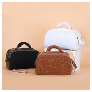Group of three stylish fuzzy makeup bags in black, brown, and white colors for travel