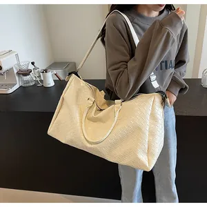 Stylish cream white woven duffle bag for women shown in a modern lifestyle setting