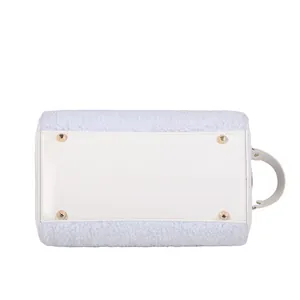 Detail view of plush cosmetic bag bottom with protective gold studs and leather base