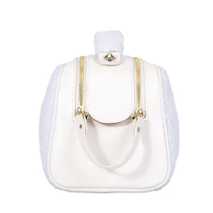Detail view of white fuzzy makeup bag with elegant gold hardware and dual zippers.