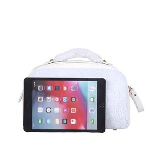 Detailed view of white sherpa fleece makeup bag shown with a tablet for size reference