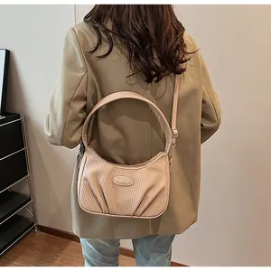 Chic pleated apricot cloud crossbody bag shown on model for a trendy casual style look