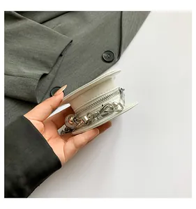 Close-up view of a minimalist white mini bag with silver chain accessory