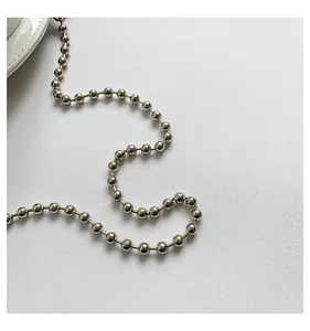Detailed view of the shiny silver metallic ball chain strap for a minimalist handbag