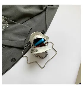 Detailed macro view of mini white heart bag interior showing lipstick storage and bead handle