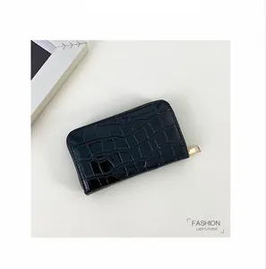 Detailansicht von oben: glänzend schwarzer Kartenhalter mit Krokoprägung und Goldzipper.