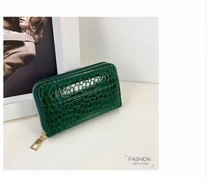 Detailansicht der glänzenden dunkelgrünen Damenhandtasche mit Krokodilstruktur