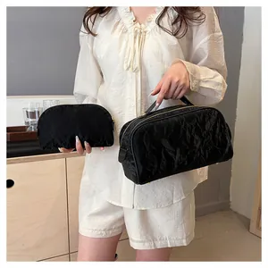 Close-up of portable black cosmetic bags with unique wrinkled texture shown in two sizes