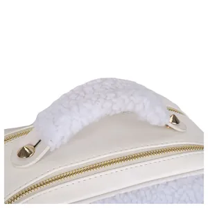 Close-up detail of a white sherpa handle on a stylish off-white faux leather makeup bag.
