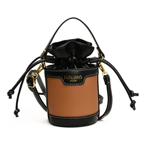 Detail of the drawstring closure and contrast stitching on the black bucket bag.