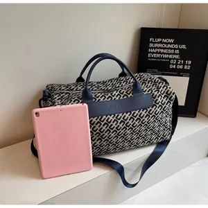 Sac de voyage à motif géométrique présenté avec une tablette pour référence de taille.