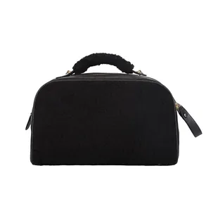 Detailed side view of black plush shearling cosmetic bag with soft fuzzy handle