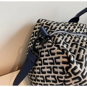 Gros plan du motif tissé et de l'attache métallique sur le sac de voyage