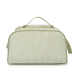 Front view of mint green cosmetic bag with marble texture and gold zipper detail