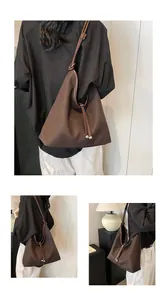 Detail view of a brown minimalist large-capacity tote bag worn by a model.