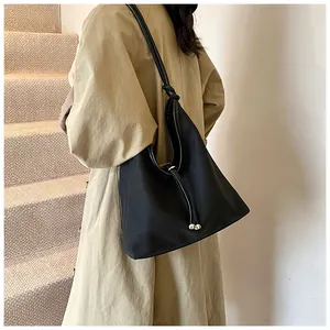 Detail of minimalist black large capacity tote bag worn on shoulder for commuting